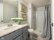 Bathroom featuring a gray vanity, elegant mirror, and a well-lit shower, exuding modern style at 2566 Maple Creek Dr, Westfield, IN 46074