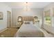 Bedroom features a tufted headboard, chandelier, bedside tables, and large window at 2566 Maple Creek Dr, Westfield, IN 46074