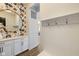An entryway featuring floral wallpaper, coat hooks, and a round mirror above a countertop at 2566 Maple Creek Dr, Westfield, IN 46074
