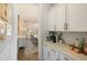 Galley kitchen featuring a marble countertop, white cabinets, and dining room view at 2566 Maple Creek Dr, Westfield, IN 46074