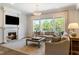 Bright living room with a fireplace, large windows, and comfortable seating area at 2566 Maple Creek Dr, Westfield, IN 46074