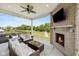 Relaxing covered patio featuring a brick fireplace and outdoor seating, ideal for enjoying the serene backyard at 2566 Maple Creek Dr, Westfield, IN 46074