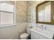 Charming powder room with stylish wallpaper, a gold framed mirror, and modern fixtures at 2566 Maple Creek Dr, Westfield, IN 46074