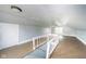 Spacious attic with light blue walls, wood floor, bright natural light, and white banister at 2627 Chase St, Anderson, IN 46016