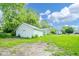 Wide shot of the spacious backyard with a detached garage and quaint two-story home at 2627 Chase St, Anderson, IN 46016