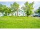 Quaint two-story home with light green siding, a red brick chimney, and a lush green lawn at 2627 Chase St, Anderson, IN 46016