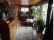 A room bathed in natural light, showcasing vintage wooden furniture, plants and an upright piano at 2731 Delaware St, Anderson, IN 46016