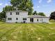 Spacious backyard featuring a white two-story house with a lush lawn and mature trees at 32 W Northeast Ct, Shelbyville, IN 46176