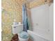 Bathroom with colorful butterfly themed wallpaper, tub/shower combination, and white tile at 32 W Northeast Ct, Shelbyville, IN 46176