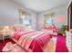 Charming bedroom featuring a pink bed, colorful decor, and bright windows at 32 W Northeast Ct, Shelbyville, IN 46176