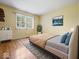 Bedroom with hardwood floors, yellow walls, window, and light-blocking blinds at 32 W Northeast Ct, Shelbyville, IN 46176