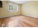 Bedroom with hardwood floors, yellow walls, window, and light-blocking blinds at 32 W Northeast Ct, Shelbyville, IN 46176
