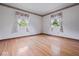 Bedroom with hardwood floors, flower wallpaper border and two windows with light-colored curtains at 32 W Northeast Ct, Shelbyville, IN 46176