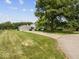 Wide view of home with long driveway leading to an attached two-car garage and expansive front yard at 32 W Northeast Ct, Shelbyville, IN 46176