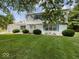 Classic two-story home features bright blue shutters accenting the front and a well-maintained lawn at 32 W Northeast Ct, Shelbyville, IN 46176