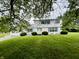Inviting two-story home with blue shutters, lush lawn, and mature shade trees at 32 W Northeast Ct, Shelbyville, IN 46176
