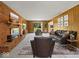 Cozy living room with brick fireplace, wood paneled walls, and comfortable leather furniture at 32 W Northeast Ct, Shelbyville, IN 46176