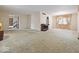 Spacious living room with neutral carpet, large windows, and a vintage chandelier at 32 W Northeast Ct, Shelbyville, IN 46176