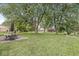 Expansive backyard with mature trees and a patio area, perfect for outdoor entertaining at 3224 Prague Rd, Indianapolis, IN 46227