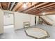 Large unfinished basement with painted floor, exposed ductwork, and stairs leading to the main level at 3224 Prague Rd, Indianapolis, IN 46227
