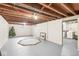 Unfinished basement featuring painted floors and walls with exposed ceiling. Laundry room can be seen in background at 3224 Prague Rd, Indianapolis, IN 46227