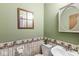 Charming half bathroom with unique wallpaper border, vanity, and decorative mirror at 3224 Prague Rd, Indianapolis, IN 46227