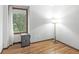 Cozy bedroom featuring a window with natural light, hardwood floors, and unique floor lamp at 3224 Prague Rd, Indianapolis, IN 46227