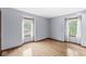 Light-filled bedroom with hardwood floors, neutral paint, and large windows with sheer curtains at 3224 Prague Rd, Indianapolis, IN 46227
