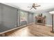 Bright room with hardwood floors, a brick fireplace, and a ceiling fan at 3224 Prague Rd, Indianapolis, IN 46227