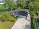 Stunning aerial view of a well-maintained ranch home with mature trees and expansive concrete driveway at 3777 W State Road 234, McCordsville, IN 46055