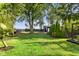 Backyard with green lawn, privacy fence, mature trees, landscaping, and detached garage at 3777 W State Road 234, McCordsville, IN 46055