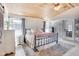 Bedroom featuring a wooden ceiling, a bed with decorative pillows, a brick wall, and a view to the backyard at 3777 W State Road 234, McCordsville, IN 46055