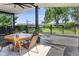 Covered deck with a table, four chairs, swing, ceiling fan, and view of the backyard at 3777 W State Road 234, McCordsville, IN 46055