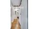 Hallway with hardwood floors leading to a bathroom, showcasing bright, neutral tones at 3777 W State Road 234, McCordsville, IN 46055