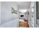 Hallway leading to the living room featuring a decorative mirror and hardwood floors at 3777 W State Road 234, McCordsville, IN 46055