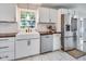 Well-lit kitchen with white cabinets, a farmhouse sink, stainless steel appliances, and wood countertops at 3777 W State Road 234, McCordsville, IN 46055
