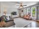 Inviting living room with hardwood floors, a ceiling fan, and large windows allowing natural light at 3777 W State Road 234, McCordsville, IN 46055