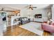 Bright living room featuring hardwood floors, a ceiling fan, and an open view of the kitchen at 3777 W State Road 234, McCordsville, IN 46055