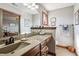 Well-lit bathroom with a granite countertop, dark wood cabinets, and a view into the bedroom through the mirror at 3784 Mansfield Dr, Brownsburg, IN 46112