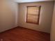This bedroom offers warm hardwood floors and a window with wood blinds at 3784 Mansfield Dr, Brownsburg, IN 46112