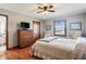 Bedroom with hardwood floors, ceiling fan, a window with view, dresser, and decorative chairs at 3784 Mansfield Dr, Brownsburg, IN 46112