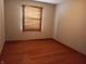 Bright bedroom has hardwood floors and a window covered by wooden blinds at 3784 Mansfield Dr, Brownsburg, IN 46112