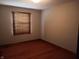 This bedroom offers warm hardwood floors and a window with wood blinds at 3784 Mansfield Dr, Brownsburg, IN 46112