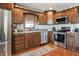 Well-equipped kitchen with stainless steel appliances, wood cabinets, tiled backsplash, and hardwood floors at 3784 Mansfield Dr, Brownsburg, IN 46112