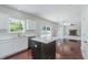 Kitchen island with stainless steel appliances, white cabinets, quartz countertops, and hardwood flooring at 4150 Huntsman Dr, Zionsville, IN 46077