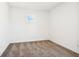 A clean, carpeted bedroom with a single window and simple, neutral color scheme at 430 Louisiana Dr, Pittsboro, IN 46167