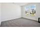 Minimalist bedroom with carpeted floors, white walls, and large windows offering natural light at 430 Louisiana Dr, Pittsboro, IN 46167
