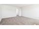A brightly lit bedroom with neutral carpet and white walls with a view to another room at 430 Louisiana Dr, Pittsboro, IN 46167