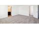 Spacious bedroom with neutral carpet and bright white walls leading to an ensuite bathroom at 430 Louisiana Dr, Pittsboro, IN 46167