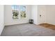 Sunlit bedroom with neutral carpeting, white walls, and a view of the exterior neighborhood at 430 Louisiana Dr, Pittsboro, IN 46167